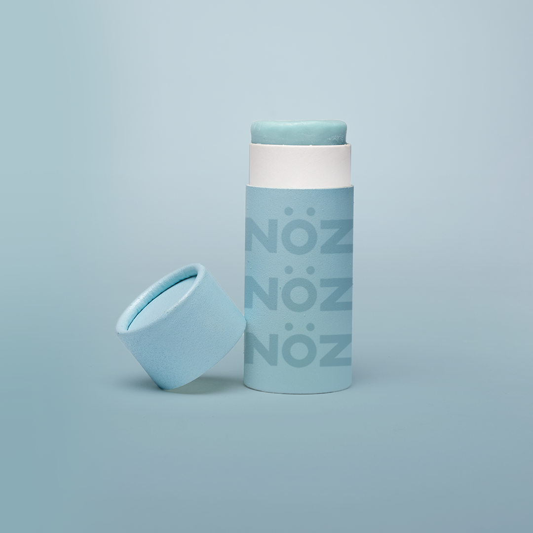 A front view of our Noz sunscreen in blue with the cap off showing some of the sunscreen stick