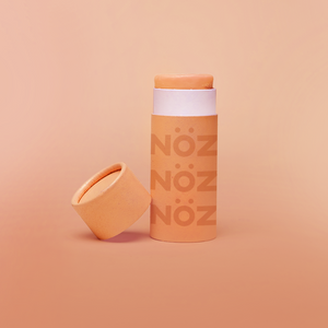 A front view of our Noz sunscreen in orange with the cap off showing some of the sunscreen stick