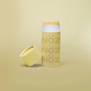 A front view of our Noz sunscreen in yellow with the cap off showing some of the sunscreen stick